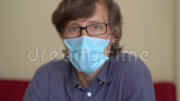 一个戴着面罩的年轻人在家中工作在隔离电晕病毒时视频的预览图