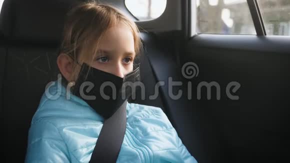 一个女孩子在车上戴上黑色防护面罩以防病毒疾病预防冠状病毒视频的预览图