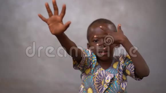 一个非洲小男孩用伸展手指击球的近景视频的预览图