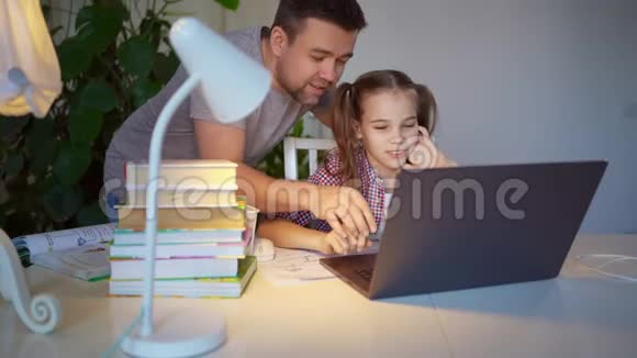 爸爸帮女儿上笔记本电脑的在线课程视频的预览图