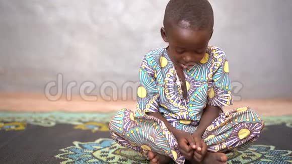 悲伤的非洲小男孩双腿交叉紧握拳头视频的预览图