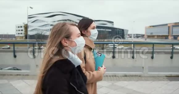 侧视两名高加索女性社会保健工作者戴着医疗面具走在空城街道上被封锁视频的预览图
