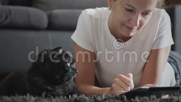 女人在家里和宠物一起用平板电脑视频的预览图
