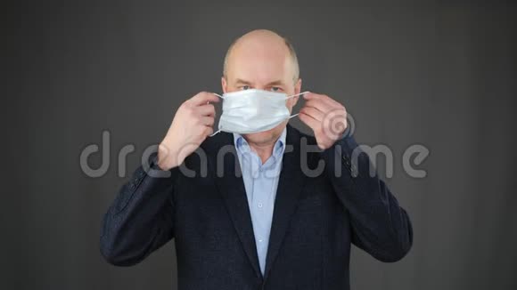 当流感流行时商人戴上面罩戴面膜以防止病毒传播的成年男子视频的预览图