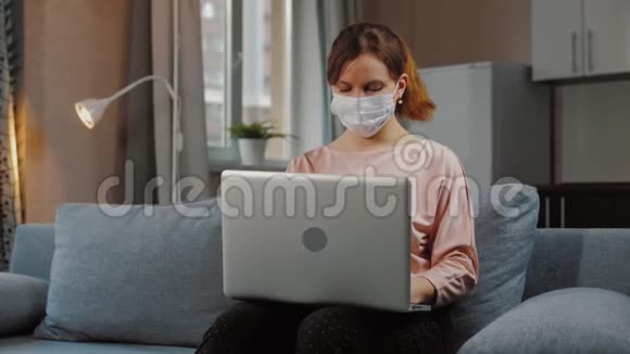 戴着医用口罩的女人远离家庭工作视频的预览图