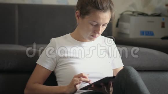 女人在家里使用数字平板电脑视频的预览图