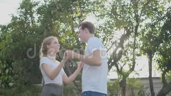 情侣们在他们家的花园里伴着黄昏的灯光跳舞他们看起来很开心视频的预览图
