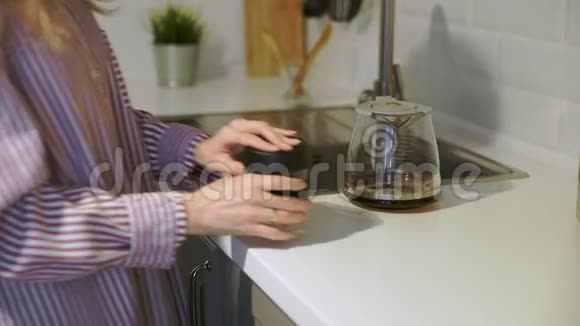 靠近的年轻女子把咖啡倒在可重复使用的杯子里在厨房里回家视频的预览图