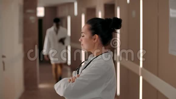 微笑女医生在医院走廊里看着摄像机视频的预览图