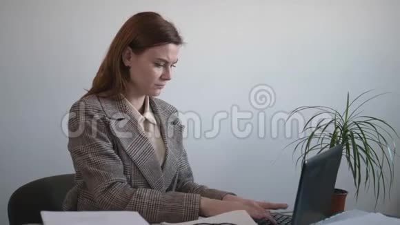 疲惫的年轻女性在电脑和电脑上做了很长时间的工作后通过缓解肌肉的紧张感在颈椎按摩中感到疼痛视频的预览图