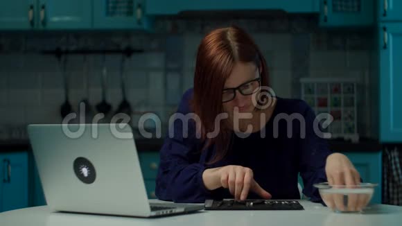 30多岁的年轻女性呆在家里在厨房里修指甲在笔记本电脑上在线看教程女人在尝试视频的预览图