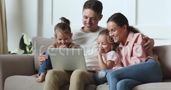 幸福的家庭夫妇和孩子们一起看有趣的电影动画片视频的预览图