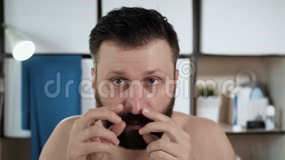 人挤压黑点浴室里有魅力的男人照镜子用手指捏着桥上的黑点视频的预览图