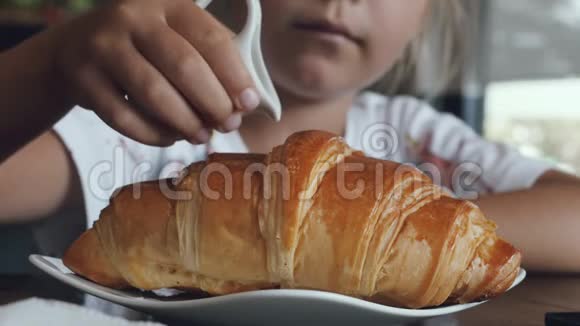 女孩把炼乳倒在牛角面包上视频的预览图