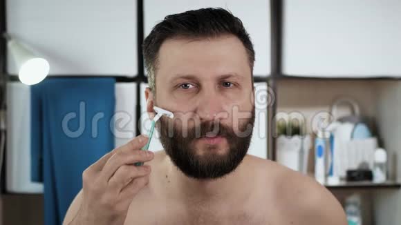 人把头发留在胡须上有魅力的白种人在浴室里照镜子把头发剃成视频的预览图