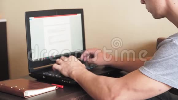 他是个在家里用笔记本电脑工作的自由职业者男人用手在笔记本键盘上打字视频的预览图