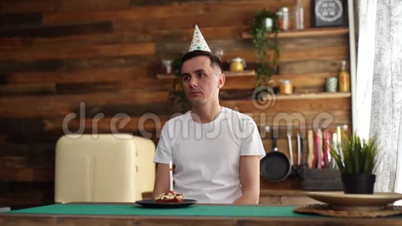 坐在生日蛋糕前看着生日蛋糕的年轻人很不高兴视频的预览图