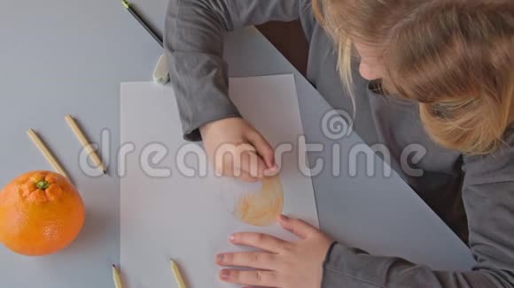 一个漂亮女孩用蜡笔画画的俯视图视频的预览图