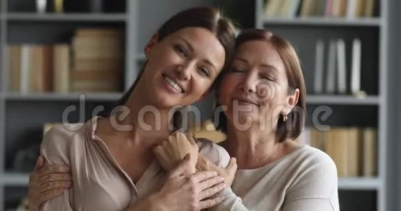 幸福多情成熟的母亲搂着成年女儿的肩膀视频的预览图
