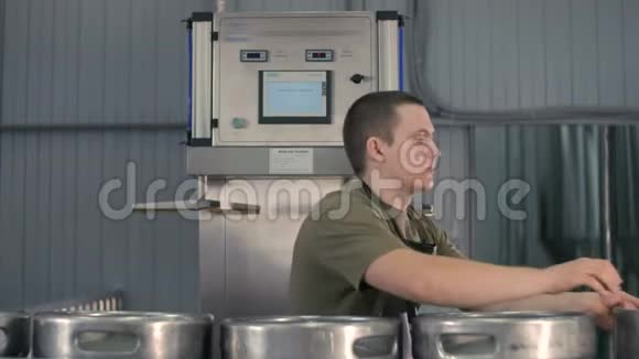 一名男性啤酒师使用自动啤酒桶灭菌机清洗和消毒啤酒桶视频的预览图