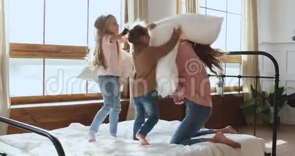 可爱的小妹妹们和微笑的妈妈打枕头视频的预览图