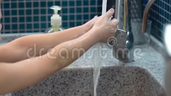 特写小男孩用肥皂洗手飞溅视频的预览图