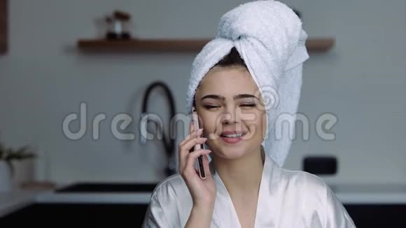 检疫期间厨房里的年轻女子洗澡的女孩洗完澡就在旁边打电话吃羊角面包视频的预览图