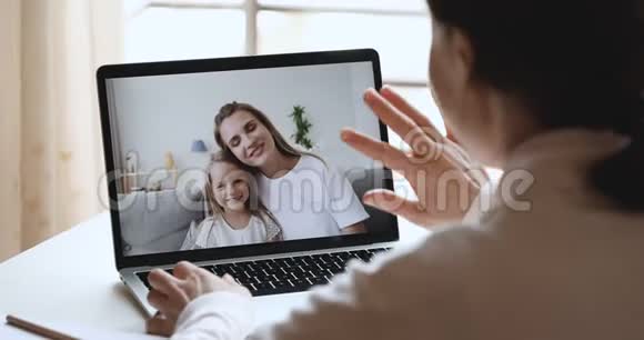 年轻女子通过网络摄像头给母亲和女儿打电话视频的预览图