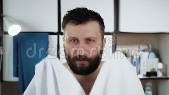 人用毛巾擦头浴室里长着漂亮胡子的白种人淋浴后用白毛巾擦头视频的预览图