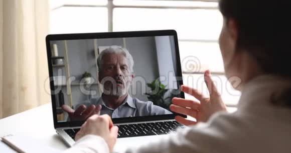 严肃的老年男性心理学家通过网络聊天咨询女性客户视频的预览图