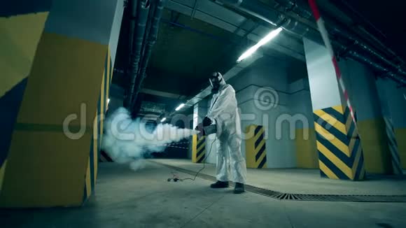 一个穿防腐服的人正在净化储存空间工人在室内使用化学药品冠状病毒消毒视频的预览图