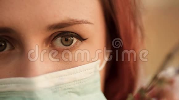 有魅力的红发女人戴着手术面具把目光移开视频的预览图
