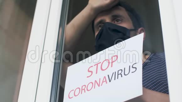 停止冠状病毒有人在窗外举着一个牌子视频的预览图