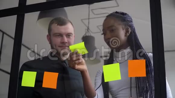企业业务多民族人士使用粘性笔记解决策略上的玻璃白板组长女视频的预览图