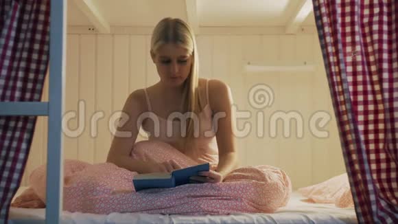 晚上穿着内衣的女人读完了书打算睡在舒适的宿舍里视频的预览图
