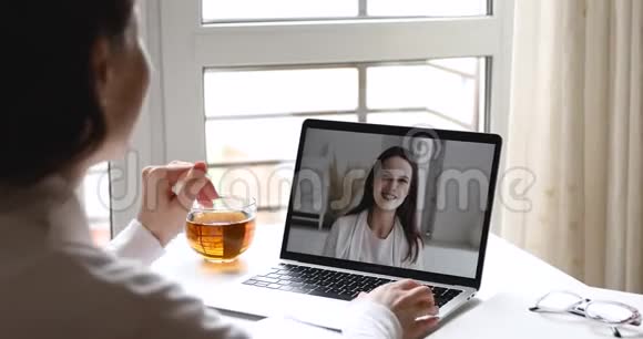 两个快乐的女孩在笔记本电脑上用网络摄像头交流视频的预览图