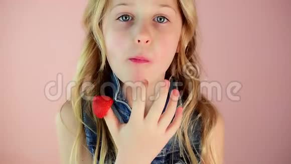 金发可爱的小女孩吃美味的成熟草莓视频的预览图