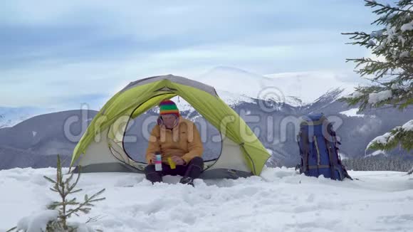 冬天在山上帐篷附近的旅行者视频的预览图