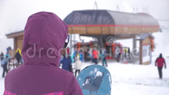 在滑雪场女孩滑雪者手里拿着滑雪板雪山上的运动女人滑雪冬季阳光明媚视频的预览图
