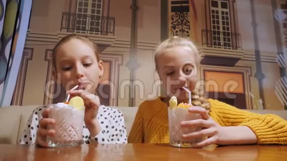十几岁的女孩在咖啡馆里喝着玻璃牛奶鸡尾酒快乐的女朋友在餐馆喝奶昔视频的预览图
