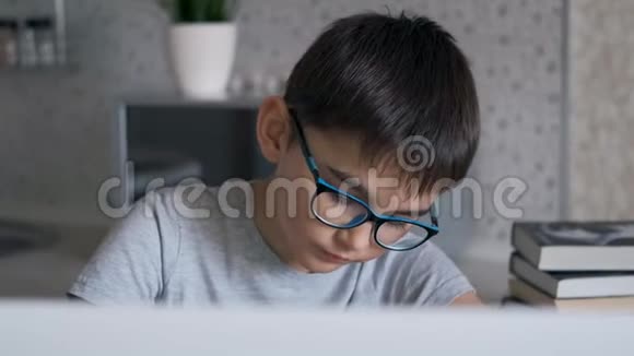 用笔记本电脑做作业的男孩的肖像视频的预览图