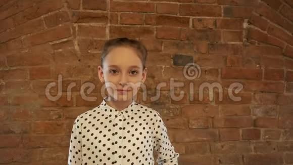 漂亮的女孩青少年与编织摆正面相机在砖墙背景模特少女寻找镜头视频的预览图