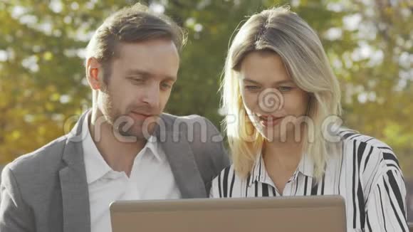 成熟的女商人在户外使用笔记本电脑时与同事交谈视频的预览图