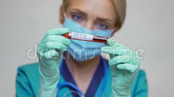 医生护士戴防护面罩和手套的妇女持有COVID19血液测试视频的预览图