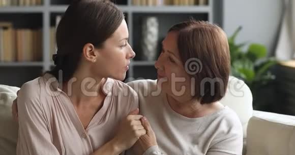 深情的中年妇女牵着长大女儿的手视频的预览图
