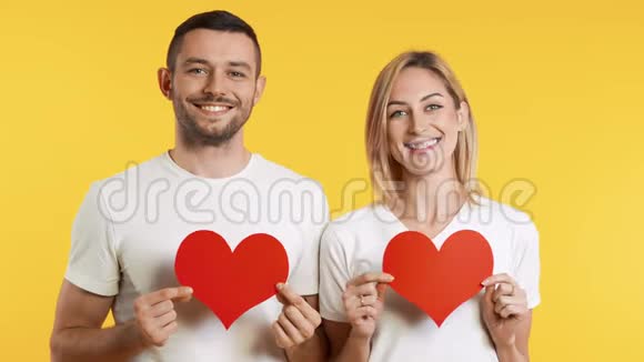 年轻的一对相爱的夫妇手里拿着大大的纸手里拿着工作室的背景视频的预览图