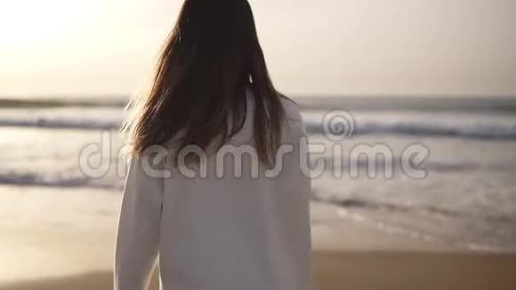 布鲁内特女士独自在沙滩上散步穿着休闲服装在海边或海边沙滩上散步的女孩视频的预览图