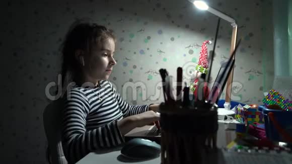 年轻的女学生在家里用笔记本电脑上课因为检疫冠状病毒视频的预览图