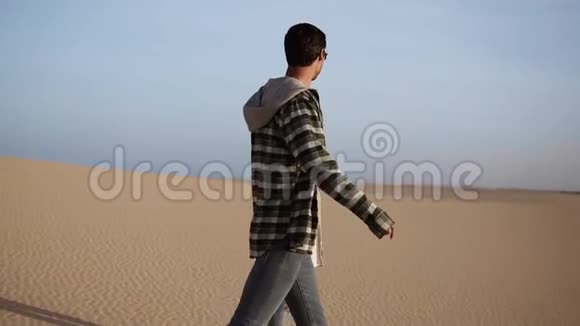 幸福的一对情侣牵着手在阳光下浪漫地走着在沙漠着两个年轻的恋人视频的预览图