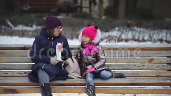 妈妈和女儿在冬季公园散步视频的预览图